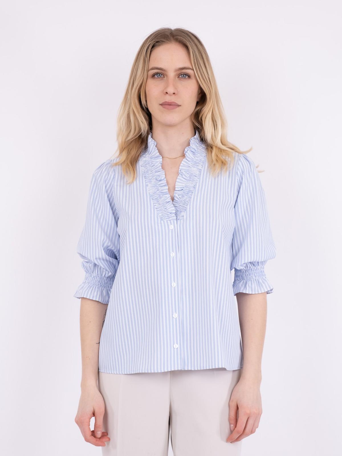 model i lyseblå bluse fra Neo Noir, med smock detaljer, forfra