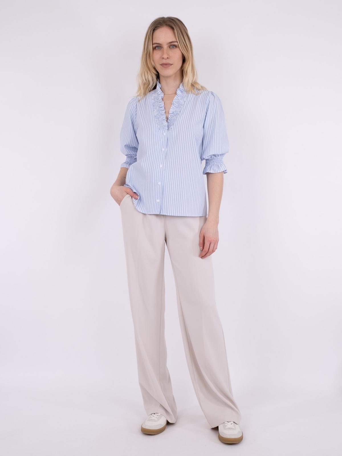 Model i hel billede af lyseblå bluse fra Neo Noir, med smock detaljer, forfra