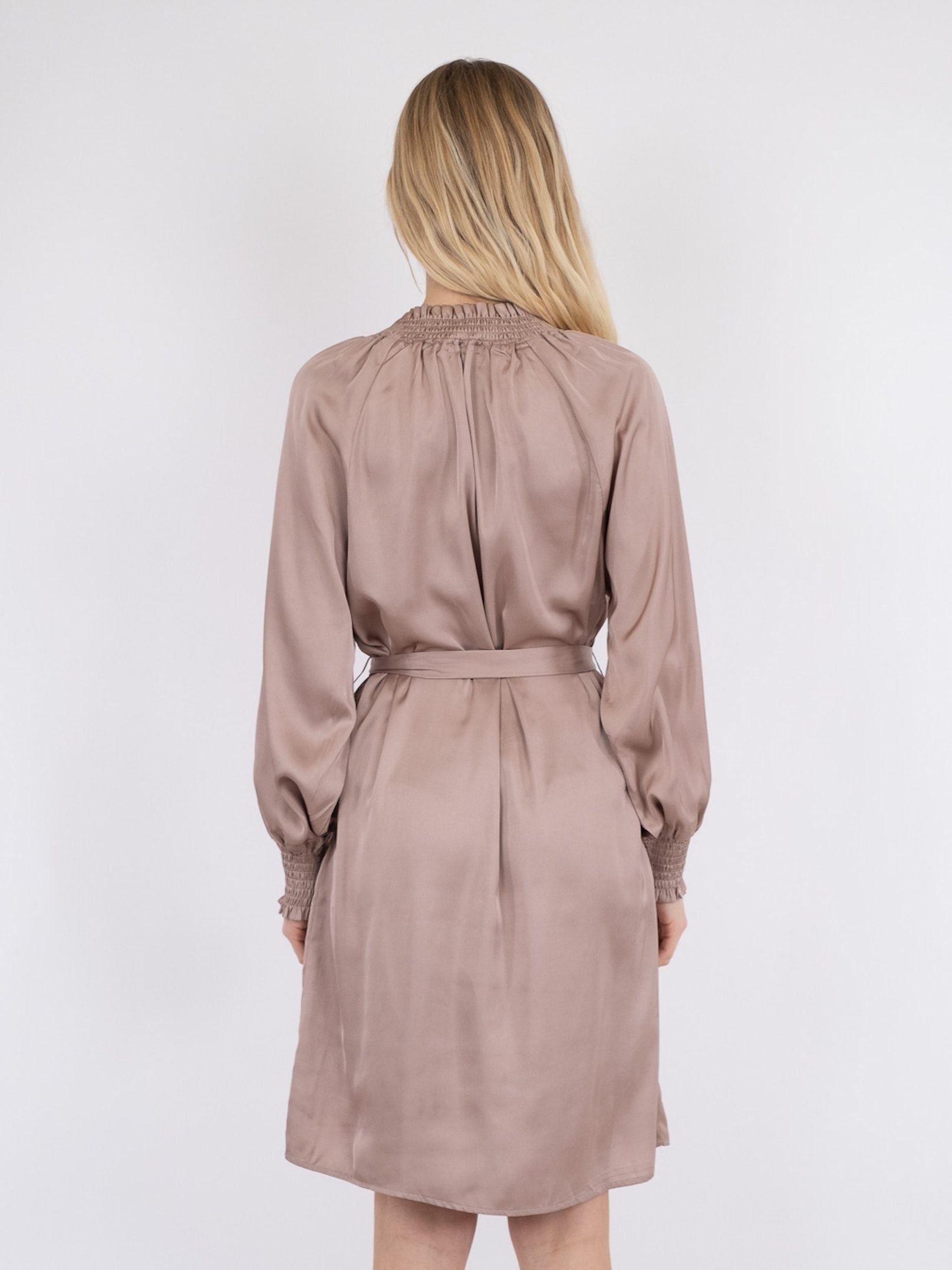 Model i kjole med bindebånd fra Neo Noir, i rosa, bagfra.